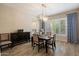 Elegant dining room with modern light fixture, wood floors, and beautiful window shutters and curtains at 22925 N 46Th St, Phoenix, AZ 85050