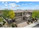 A stunning exterior elevation showcasing a two-story home with stone accents, a three-car garage, and lush landscaping at 22925 N 46Th St, Phoenix, AZ 85050