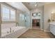 Bright main bathroom with a walk-in shower, soaking tub, and a walk-in closet at 22925 N 46Th St, Phoenix, AZ 85050