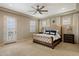 Inviting primary bedroom featuring tray ceiling, fan, plantation shutters, and private balcony access at 22925 N 46Th St, Phoenix, AZ 85050