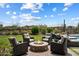 Cozy outdoor seating area featuring a stone fire pit surrounded by comfortable chairs and lounging in the sun at 22925 N 46Th St, Phoenix, AZ 85050