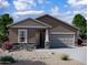 Charming single-story home with neutral stucco and stone accents, complemented by a well-maintained desert landscape at 24260 W Pecan Rd, Buckeye, AZ 85326