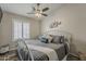 Cozy bedroom featuring a queen-sized bed, gray bedding, wood floors, and a ceiling fan at 2579 E Camellia Dr, Gilbert, AZ 85296