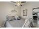 Bedroom with a decorative bed, a ceiling fan, wood floors, and sliding window covers at 2579 E Camellia Dr, Gilbert, AZ 85296
