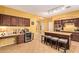 Well-lit kitchen boasts dark wood cabinetry and a breakfast bar for casual dining at 2610 E Leiber Ln, Phoenix, AZ 85024