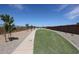 A landscaped community walking path with grass and desert landscaping alongside a brick wall at 294 W Flax Dr, San Tan Valley, AZ 85140