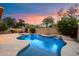 Captivating backyard with a freeform pool, spa, and waterfall feature, enveloped by mature trees and vibrant plants at 35206 N 27Th Ave, Phoenix, AZ 85086