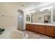Bright primary bathroom with dual vanities, garden tub, a separate shower and tile floors at 35206 N 27Th Ave, Phoenix, AZ 85086