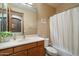 Clean bathroom with oak vanity, mirrored medicine cabinet, and shower/tub with curtain at 35206 N 27Th Ave, Phoenix, AZ 85086