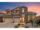 Gorgeous two-story home with a stone accent exterior and a spacious three-car garage at dusk at 35206 N 27Th Ave, Phoenix, AZ 85086