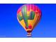 Vibrant hot air balloon featuring a cactus design soars against a clear blue sky, offering a unique scenic view at 35206 N 27Th Ave, Phoenix, AZ 85086