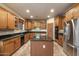 Well-equipped kitchen features oak cabinets, black granite counters, and a stainless steel refrigerator at 35206 N 27Th Ave, Phoenix, AZ 85086