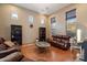 Spacious living room with large windows, wood floors, and a leather sofa, creating a cozy atmosphere at 35206 N 27Th Ave, Phoenix, AZ 85086