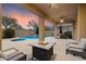Relaxing patio with a cozy fire pit and comfortable seating, overlooking a sparkling pool and serene backyard at 35206 N 27Th Ave, Phoenix, AZ 85086