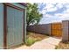 View of a small backyard, including a storage shed, gate and some bare dirt at 3646 N 67Th Ave # 20, Phoenix, AZ 85033