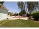 The backyard includes a spacious grass area surrounded by mature trees and shrubbery at 3741 W Davidson Ln, Phoenix, AZ 85051