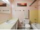 Charming bathroom with pink walls, vanity, toilet, and yellow tiled bath at 3741 W Davidson Ln, Phoenix, AZ 85051