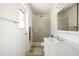 Bright bathroom with white vanity, shower, and access door to the outside at 3741 W Davidson Ln, Phoenix, AZ 85051