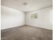 Clean bedroom featuring neutral carpet, white walls, and a single window with security bars at 3741 W Davidson Ln, Phoenix, AZ 85051