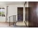 Inviting entryway showcasing a dark wooden door, mirrored wall accents, and decorative window with ample natural light at 3741 W Davidson Ln, Phoenix, AZ 85051