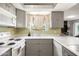 A charming kitchen featuring neutral-toned countertops, classic cabinetry, and a bright window over the sink at 3741 W Davidson Ln, Phoenix, AZ 85051