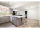 Bright, open kitchen with gray cabinets, a spacious island with seating, and durable tile flooring at 3741 W Davidson Ln, Phoenix, AZ 85051