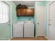 Functional laundry room with a white washer and dryer set, and upper cabinets for storage at 3741 W Davidson Ln, Phoenix, AZ 85051