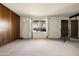 Bright living room features a large window, vintage wooden accents, and neutral-toned carpeting at 3741 W Davidson Ln, Phoenix, AZ 85051