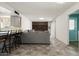 Open-concept living room featuring a breakfast bar, gray sofa and built-in shelving at 3741 W Davidson Ln, Phoenix, AZ 85051