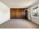 Spacious living room with carpet, paneled wall, unique floor lamp, and ironwork on window at 3741 W Davidson Ln, Phoenix, AZ 85051