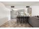Bright, open-concept living area with tile floors, gray cabinets, and a kitchen bar with seating at 3741 W Davidson Ln, Phoenix, AZ 85051