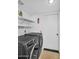Well-organized laundry room with modern washer and dryer and overhead storage shelves at 3926 E Lavender Ln, Phoenix, AZ 85044