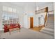 Bright living room featuring a vaulted ceiling, a large window, and an open staircase leading to the second floor at 3926 E Lavender Ln, Phoenix, AZ 85044