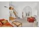 Bright living room featuring an arched entrance, staircase, hardwood floors, and a cozy seating area at 3926 E Lavender Ln, Phoenix, AZ 85044