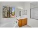 A bright main bathroom featuring a soaking tub under a window, vanity, and step-in shower at 3926 E Lavender Ln, Phoenix, AZ 85044
