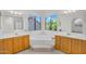A spacious main bathroom features double vanities, a soaking tub, and large windows at 3926 E Lavender Ln, Phoenix, AZ 85044