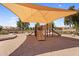 Community playground featuring a shade structure, slides, and sand ground covering at 3926 E Lavender Ln, Phoenix, AZ 85044
