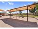 Community playground featuring swings, shade structure, and sand ground covering at 3926 E Lavender Ln, Phoenix, AZ 85044