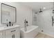 Modern bathroom featuring a soaking tub, marble-tiled shower, and vanity with matte black hardware at 405 E Cornell Dr, Tempe, AZ 85283