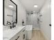 Bright bathroom featuring a soaking tub, marble-tiled shower, and vanity with matte black hardware at 405 E Cornell Dr, Tempe, AZ 85283