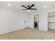 Bright bedroom featuring a ceiling fan, light wood floors, and an ensuite laundry room and walk-in closet at 405 E Cornell Dr, Tempe, AZ 85283