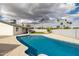 An in-ground pool in a yard with a covered patio and palm trees at 405 E Cornell Dr, Tempe, AZ 85283