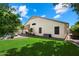 Spacious backyard with manicured lawn, partial view of pool, and covered patio with furniture at 420 S Dodge Dr, Chandler, AZ 85225