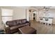 Cozy living room featuring stylish wood floors, a leather couch, and a bar with seating, perfect for relaxing and entertaining at 420 S Dodge Dr, Chandler, AZ 85225