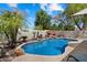 Backyard pool area with rock waterfall feature, mature landscaping, and privacy wall at 420 S Dodge Dr, Chandler, AZ 85225