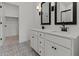 Stylish bathroom features a double sink vanity with elegant fixtures and patterned tile floor at 42405 W Peters Dr, Maricopa, AZ 85138