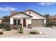Charming single-story home featuring a well-manicured desert landscape, covered entryway, and attached two-car garage at 42405 W Peters Dr, Maricopa, AZ 85138