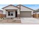 Charming single-story home featuring a two-car garage, covered porch, and low maintenance desert landscaping at 42405 W Peters Dr, Maricopa, AZ 85138