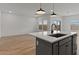 Bright kitchen with stainless steel appliances, island with seating, and sliding glass door to patio at 42405 W Peters Dr, Maricopa, AZ 85138