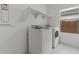 Convenient laundry room with modern appliances, overhead shelving, and a bright window at 42405 W Peters Dr, Maricopa, AZ 85138